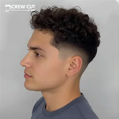 Short curly blowout low taper fade curly hair style on a man.