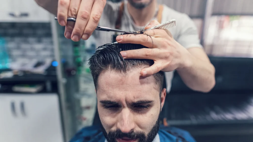 Person looking in mirror thinking should I cut my hair